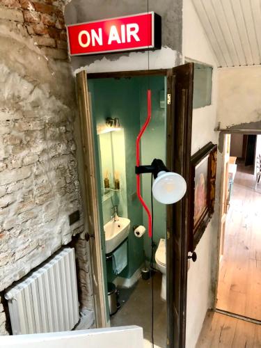 a bathroom with a sink and a on air sign at Charming and Design Attic Loft Central Milan in coolest area Navigli Ticinese in Milan