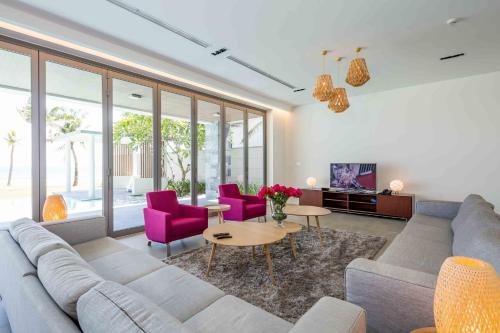 a living room with a couch and purple chairs at Vacation Home Ocean Villas in Da Nang