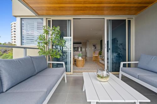 a living room with two couches and a table at The Haven on Blue Bay in Mandurah