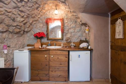 uma casa de banho com um lavatório e um espelho em Traditional stone build private studio em Verga Kalamata