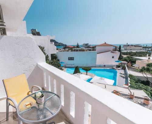 a balcony with a table and a view of a pool at Myrtis Spa Hotel in Plakias