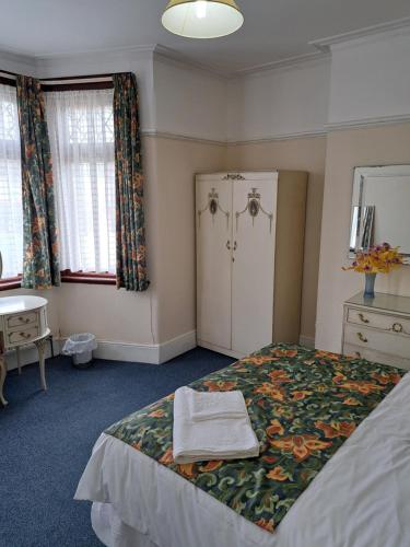 - une chambre avec un lit, une table et des fenêtres dans l'établissement Luxury super double bedroom London Seven Kings Train station, à Seven Kings