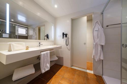 uma casa de banho com um lavatório e um chuveiro em Oassium Hotel - Adults Only em La Pineda
