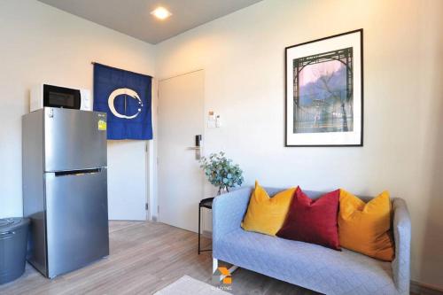 a living room with a blue couch and a refrigerator at Arasa House by G Living -6mins MRT Klong Bang Phai in Ban Khung Taphao