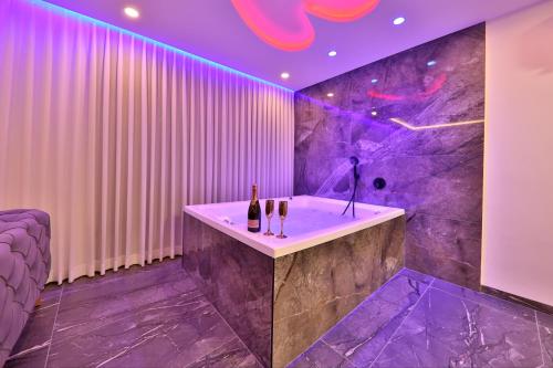 a bathroom with a bath tub with purple lighting at חלום מול הים - סוויטת נופש יוקרתית עם ג'קוזי ונוף לים in Haifa