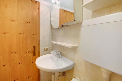 uma casa de banho com um lavatório branco e um espelho. em Casa Valentina em Livigno