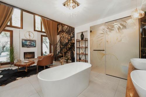 a bathroom with a tub and a living room at Toplik Village Resort in Lukavica