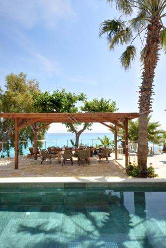 a pool with a gazebo and a table and chairs at Paradisso Beach Villas in Zakynthos Town