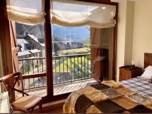 a bedroom with a large window with a view at Elegante apartamento en Escarrilla con vistas al valle in Escarrilla