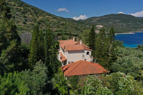 a house with red roofs on a hill next to a lake at VKastri in Vasiliki