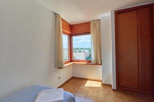 a bedroom with a bed and a large window at Apartaments Golf Mar in Pals