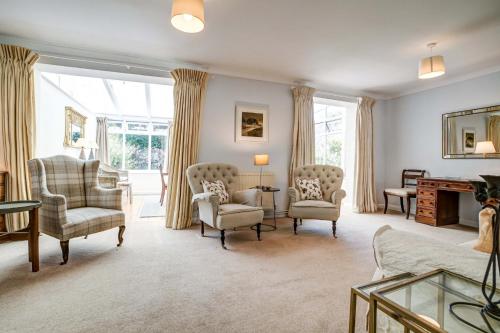 a living room with chairs and a couch and a table at High Trees Blenheim View in Woodstock