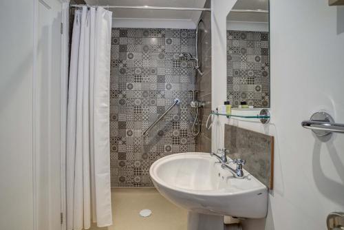 a bathroom with a sink and a shower at High Trees Blenheim View in Woodstock
