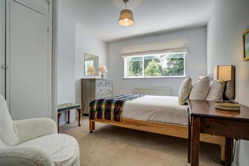 a bedroom with a bed and a desk and a window at High Trees Blenheim View in Woodstock