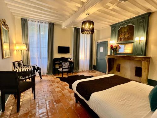 a bedroom with a bed and a chair and a desk at Les Glycines Vézelay in Vézelay