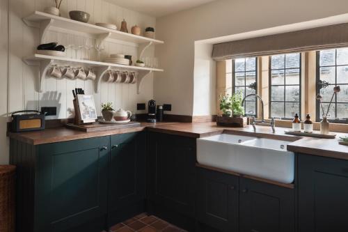 a kitchen with a large sink and a window at The Little Barn in Lower Slaughter