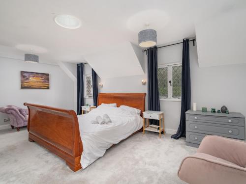 um quarto com uma cama grande e uma cadeira em Pass the Keys Prestigious 5 Bed Retreat Spacious Tranquil Haven em Radlett