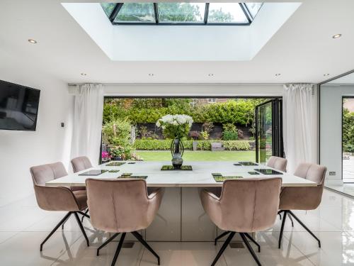 a dining room with a white table and chairs at Pass the Keys Prestigious 5 Bed Retreat Spacious Tranquil Haven in Radlett