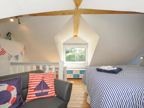 ein Schlafzimmer mit einem Bett, einem Sofa und einem Fenster in der Unterkunft Farleigh Cottage in Looe