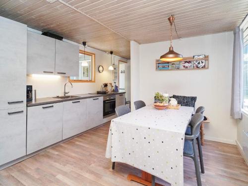 een keuken met een tafel en een keuken met witte kasten bij 5 person holiday home in Eskebjerg in Eskebjerg