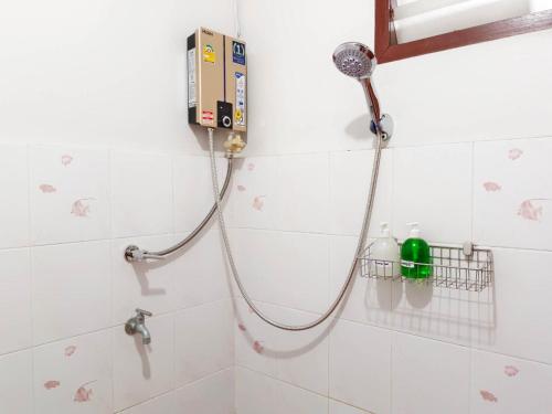a shower with a hose attached to a wall at Apilapa House in Chiang Mai