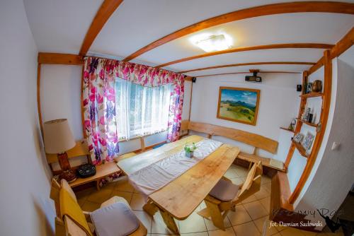 una camera con tavolo, sedie e finestra di Pokoje pod Krzywym Dachem a Karpniki