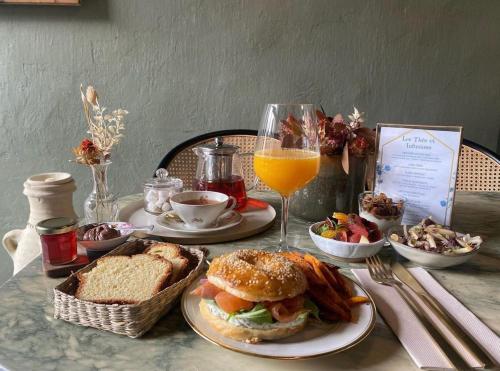 a table with a sandwich and a glass of orange juice at La maison du tripot in Honfleur