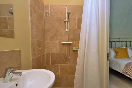 a bathroom with a sink and a shower with a bed at The Old Parlour in Frome