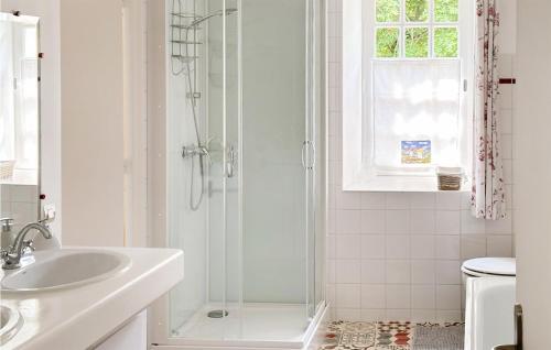 La salle de bains blanche est pourvue d'une douche et d'un lavabo. dans l'établissement Nice Home In Auxais With Kitchenette, à Auxais