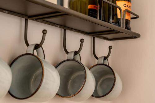 a group of pots and pans hanging on a wall at Royal View Apartments in Kirkby Lonsdale