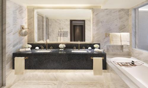 a bathroom with a tub and a large mirror at Four Seasons Hotel Riyadh in Riyadh