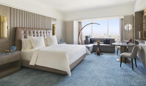 a bedroom with a large bed and a living room at Four Seasons Hotel Riyadh in Riyadh