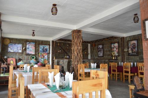 a restaurant with tables and chairs in a room at Zan-Seyoum Hotel - Lalibela in Lalībela