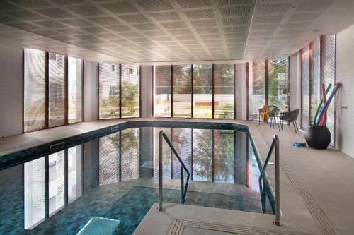 an indoor swimming pool in a building with windows at Résidence DOMITYS CHATEAU CAMAS in Pin-Balma