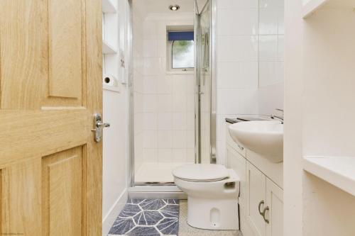 a bathroom with a toilet and a sink at Kipper Cottage in Wootton Bridge