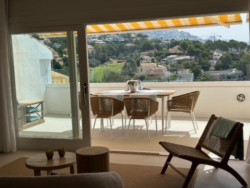 a room with a table and chairs on a balcony at Cosy2stay Moncayo Golf Apartememt in Altea la Vieja