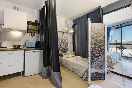 a kitchen and a bedroom with a bed in a room at Los Abrigos oceano al alba wifi in Los Abrigos