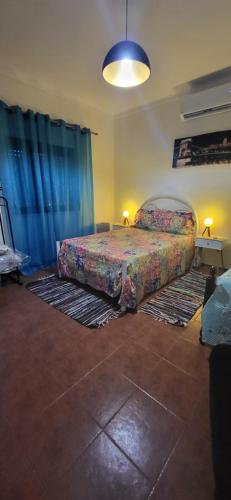 a bedroom with two beds with blue curtains at Casa Mendonça in Coruche