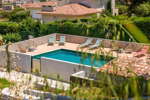 a swimming pool with two chairs and avisorvisor at Résidence Ochji di Mare in Propriano