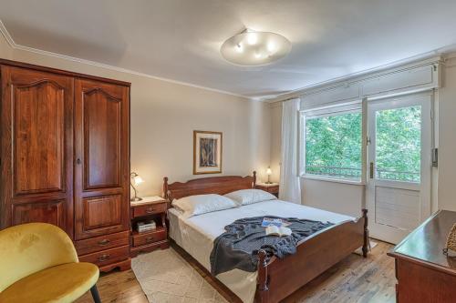 sypialnia z łóżkiem, biurkiem i oknem w obiekcie Holiday House Mlin w mieście Kras