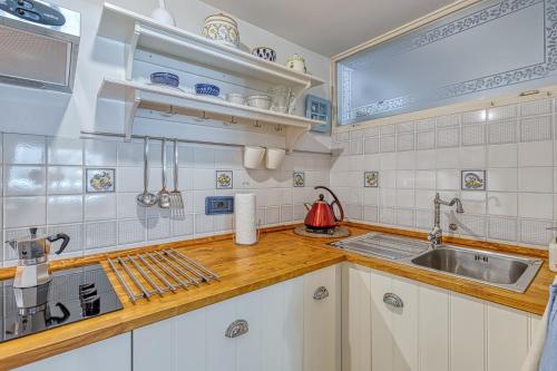 a kitchen with white cabinets and a sink at Holiday House Mlin in Kras