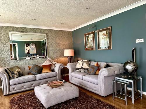 uma sala de estar com dois sofás e um espelho em Gleneagles Lettings em Auchterarder