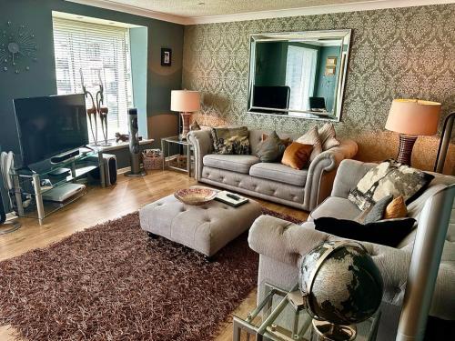a living room with two couches and a television at Gleneagles Lettings in Auchterarder