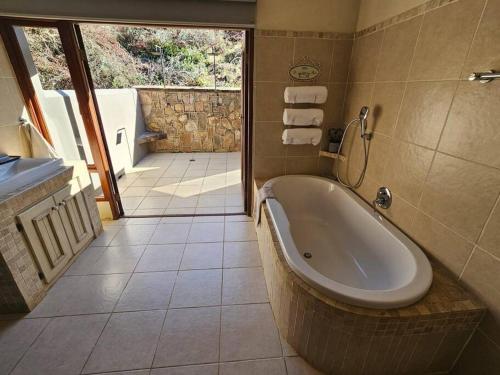 ein Badezimmer mit Badewanne und Waschbecken in der Unterkunft Stone Cottage in Dullstroom