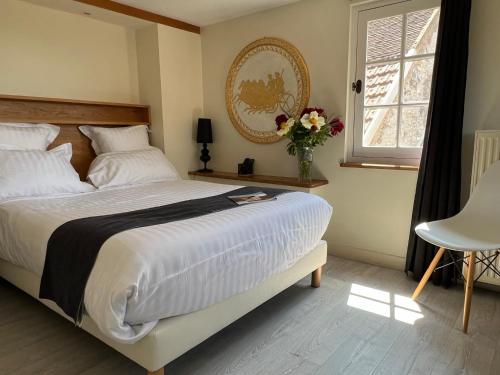 Un pat sau paturi într-o cameră la Les Glycines Vézelay