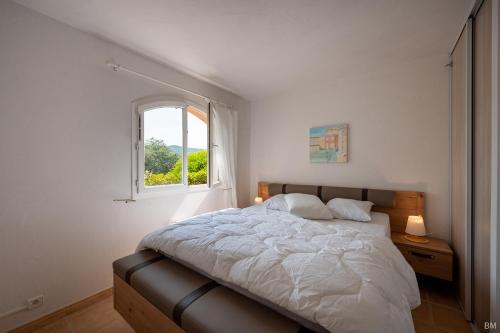 um quarto com uma cama grande e uma janela em Esprit du Sud Le Rocher d'Azur em La Rouviere