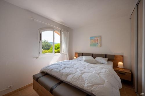 une chambre avec un grand lit et une fenêtre dans l'établissement Esprit du Sud Le Rocher d'Azur, à La Rouviere
