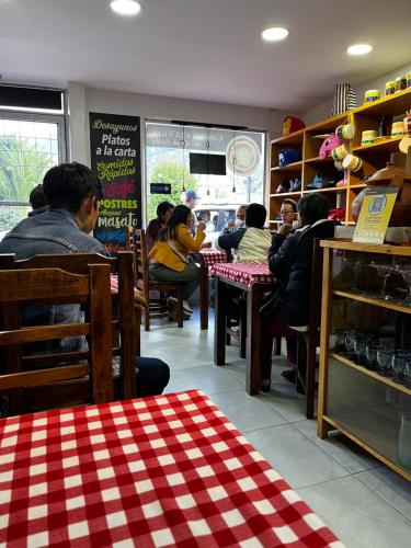 un grupo de personas sentadas en mesas en un restaurante en Camino A La Villa Cucaita Hotel en Cucaita