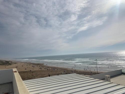 a view of the beach from the balcony of a building at Belle appartement situé à la plage mahdia in Kenitra