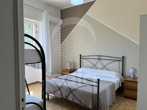 een slaapkamer met twee bedden en een gestreepte muur bij Villa Capitano - piscina privata By Cala Salento in Torre Lapillo